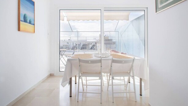 A dining area with a table and chairs, large windows, and a city view. - Neos Kosmos 1Bd Apt with Stunning Views (Athens)