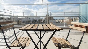 A rooftop terrace with a wooden table and benches, offering a view of the cityscape. - Neos Kosmos 1Bd Apt with Stunning Views (Athens)