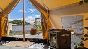 A tent with a view of a hill, a wood stove, and a pot on a table. - Lovely home in Sejerø with WiFi (Sejerø)