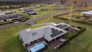 A residential area with houses, a swimming pool, and solar panels on the roofs. - Serenity Estate Hunter Valley (Millfield)