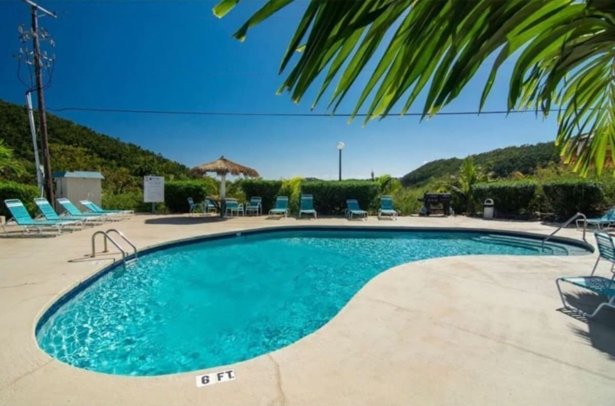A swimming pool with lounge chairs and a sign indicating 8 feet depth.