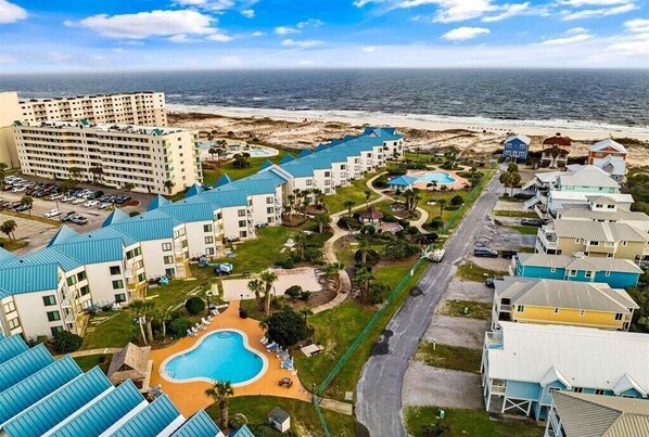 A resort with multiple buildings, a large pool, and a beach view. - Surf's Up Beachfront Resort Studio | Pools + Beach Access (Gulf Shores)