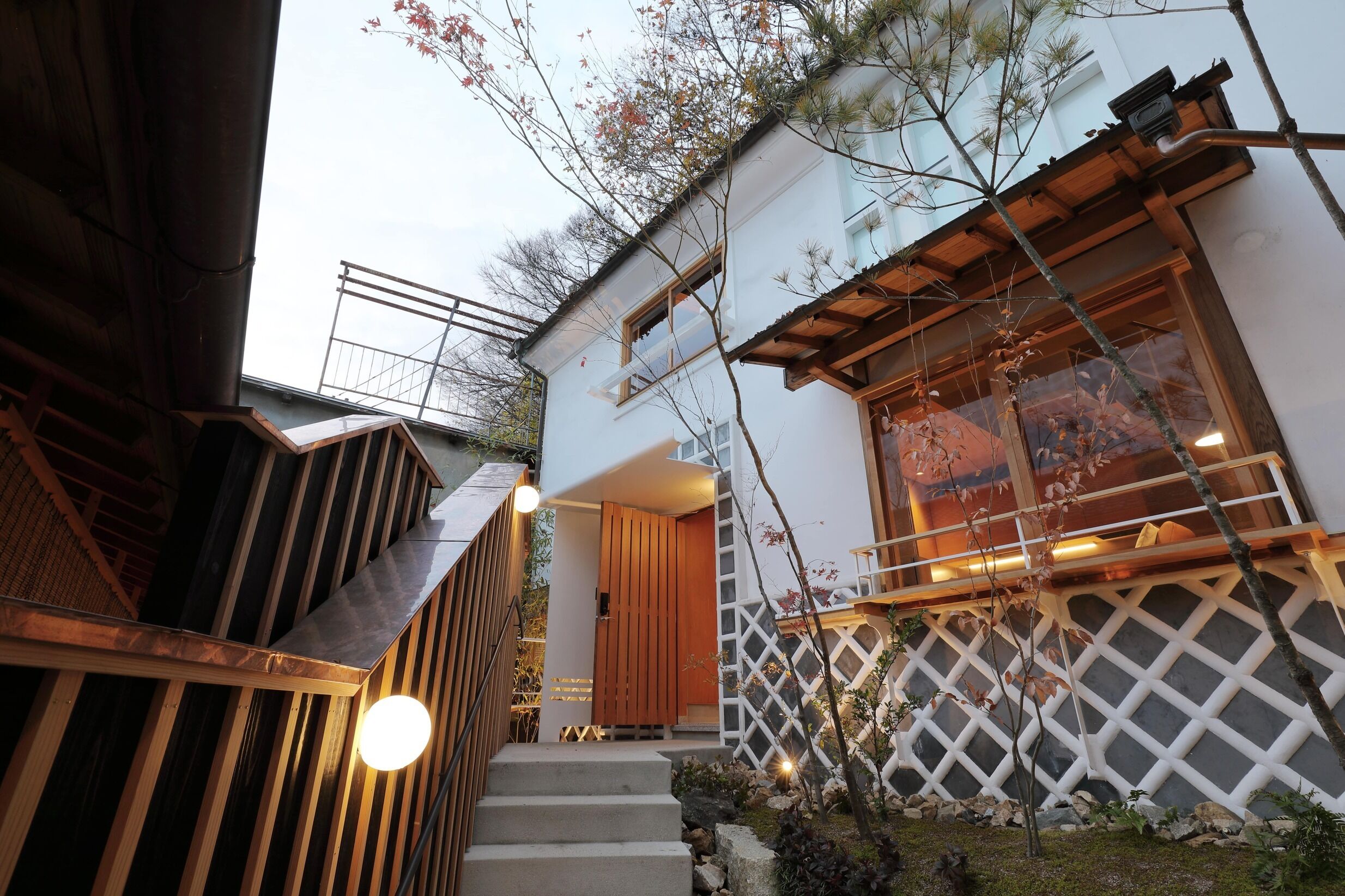 A modern building with a wooden staircase, a wooden door, and a white lattice wall.