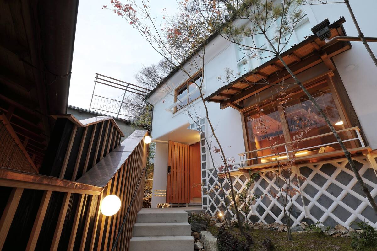 A modern building with a wooden staircase, a wooden door, and a white lattice wall.