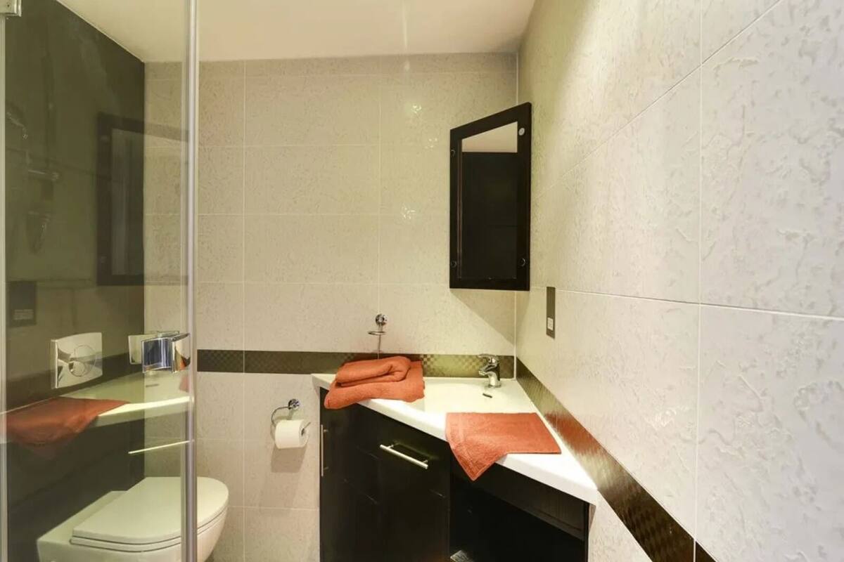 A bathroom with a toilet, a sink, and a glass shower enclosure.
