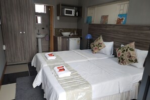 A hotel room with two beds, a sink, a microwave, and a small kitchenette. - Room-home of Peace and Tranquility (Pretoria)