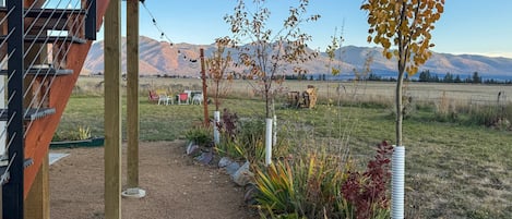 A garden with a gravel path, plants, and a view of mountains.