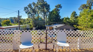 A patio with two white chairs and a metal table, surrounded by a white lattice fence. - 2 Mi to Dtwn Natchez: Cozy Home w/ Yard & Patio! (Natchez)