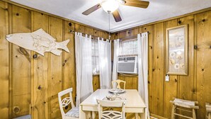 A wooden-paneled room with a dining table, chairs, a ceiling fan, and a fish decoration. - < 1 Mi to Fishing: Springville Home w/ Fireplace! (Springville)
