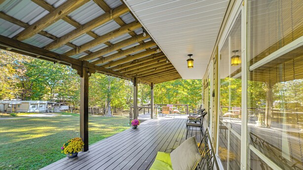 A covered deck with a wooden floor, a cushioned bench, and a flower pot. - < 1 Mi to Fishing: Springville Home w/ Fireplace! (Springville)