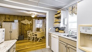 A kitchen with wooden flooring, a dining table with chairs, a refrigerator, a sink, and a microwave. - < 1 Mi to Fishing: Springville Home w/ Fireplace! (Springville)