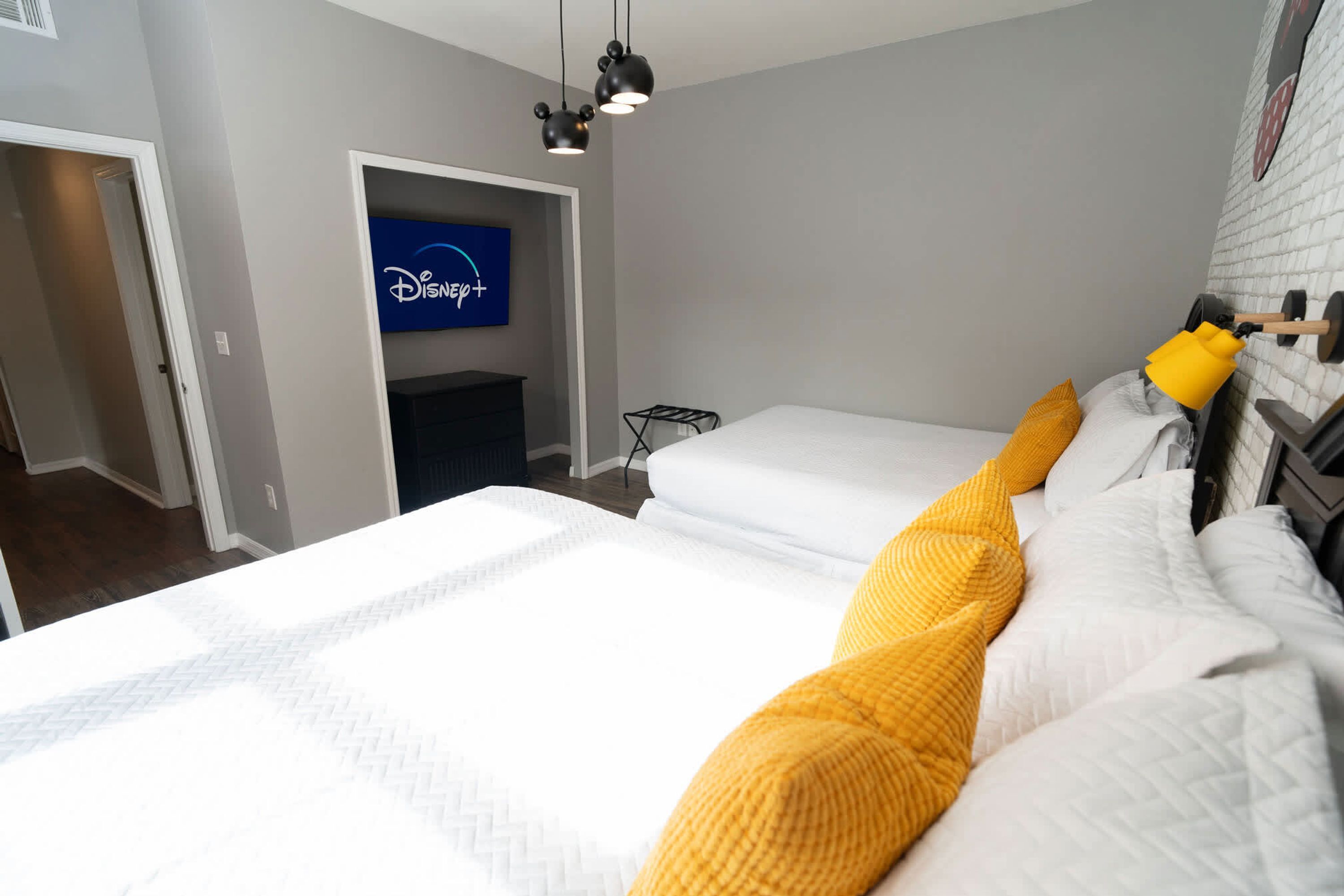 A hotel room with a large bed, a TV mounted on the wall, and a small seating area.