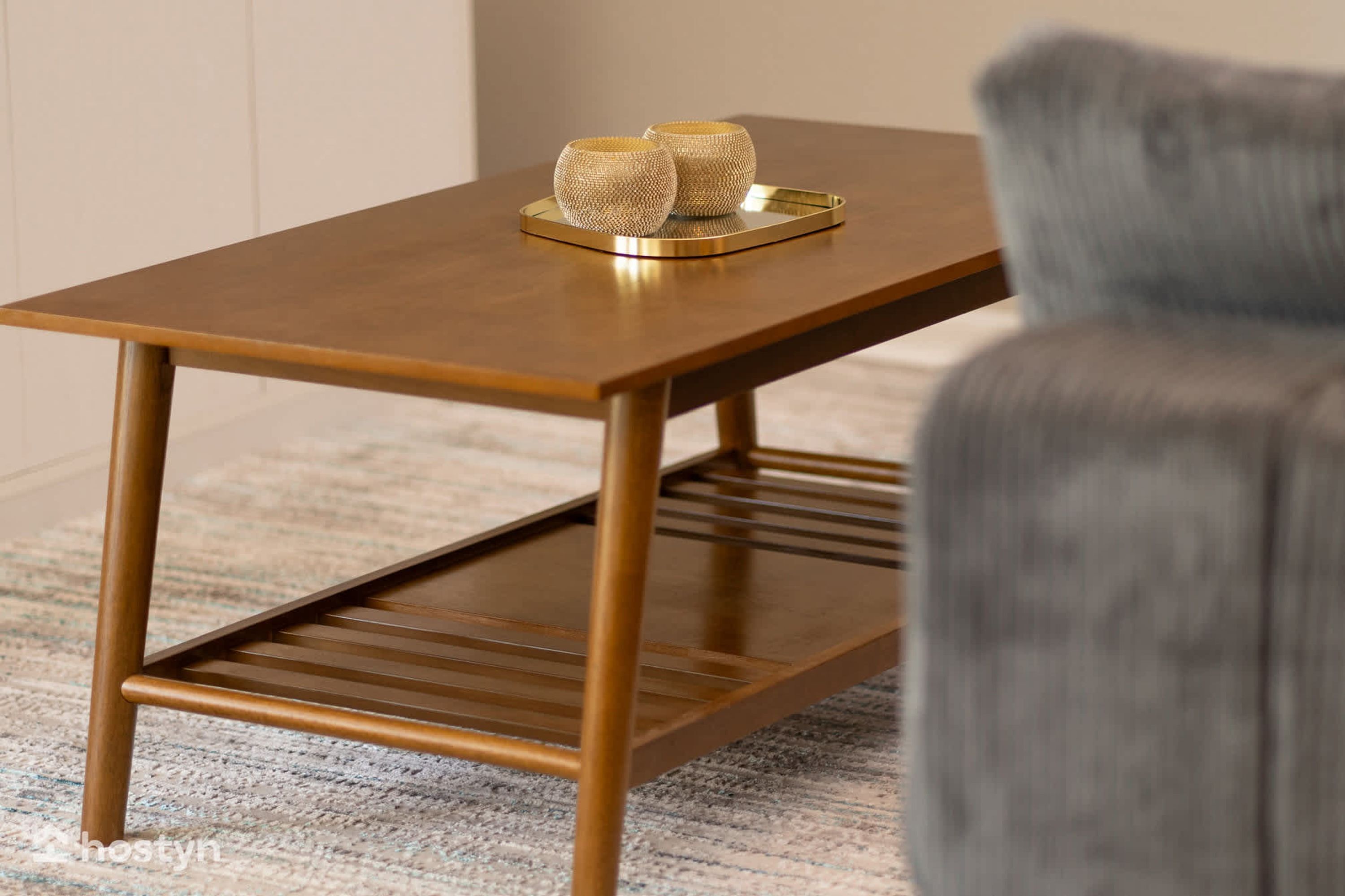 Une table moderne, rectangulaire, en bois, avec un plateau en métal et deux objets sphériques posés dessus.