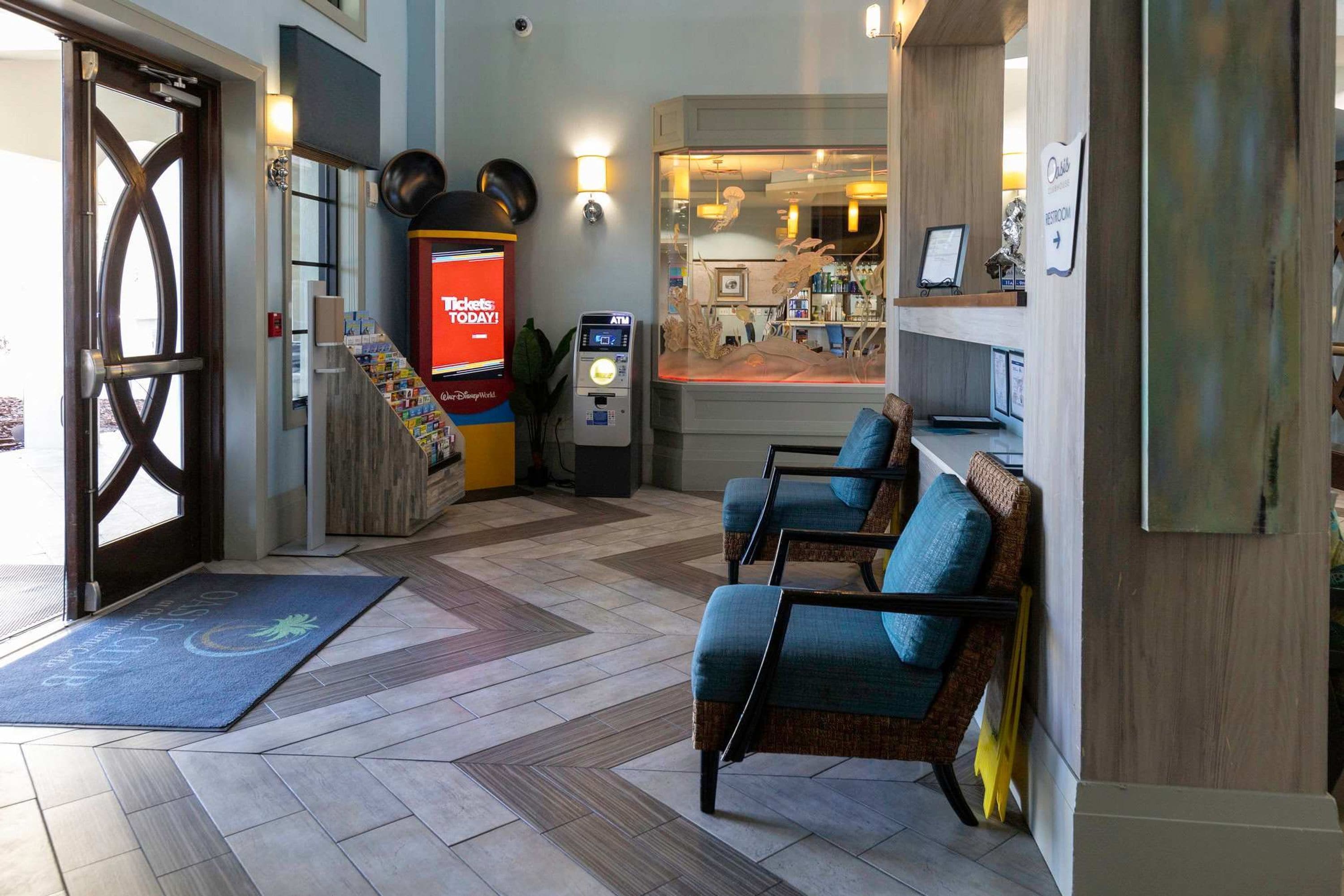 A hotel lobby with a reception desk, seating area, and a ticket machine.