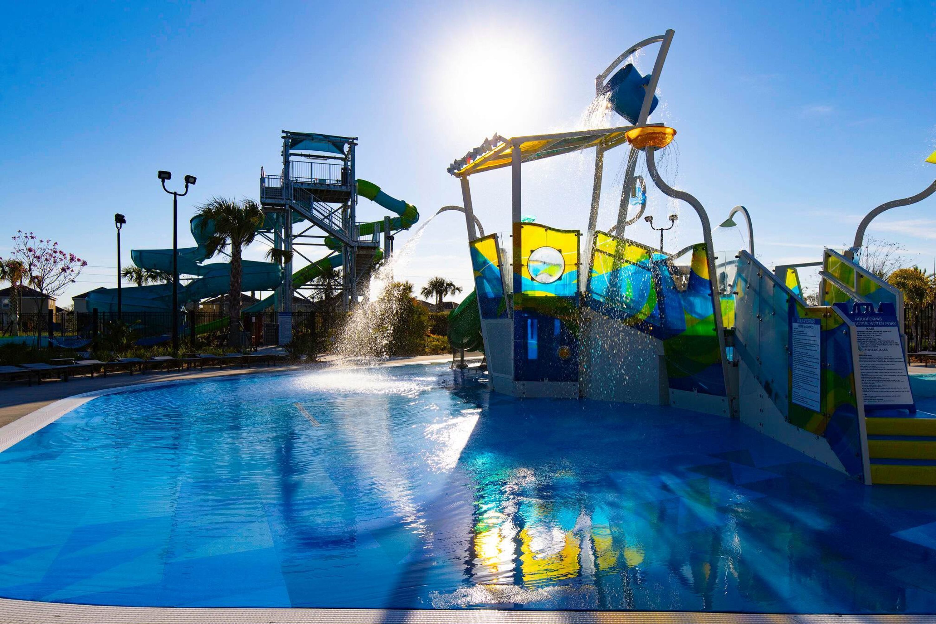 A water park with a large pool, water slides, and a water feature spraying water.
