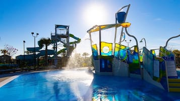 A water park with a pool, slides, and a water fountain.