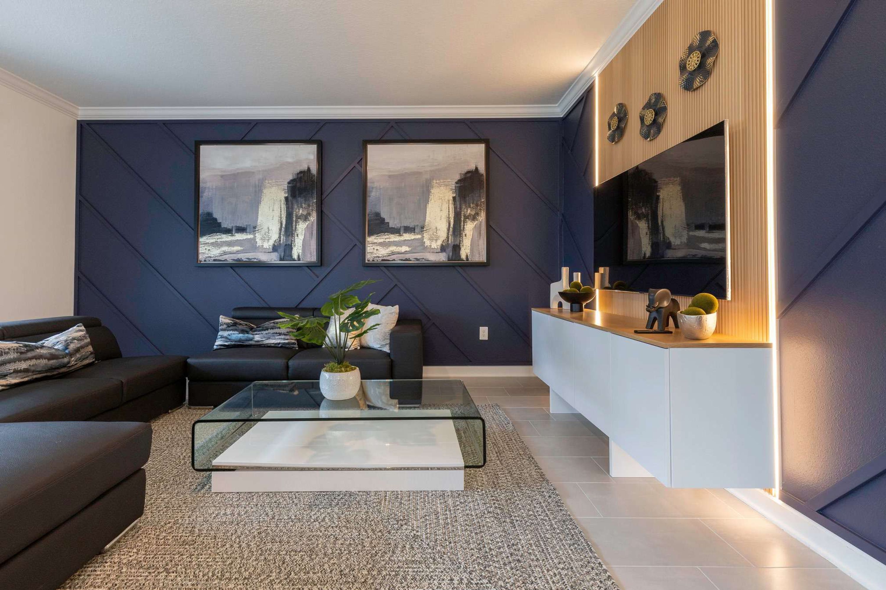 A modern living room with a sofa, coffee table, and artwork on the wall.