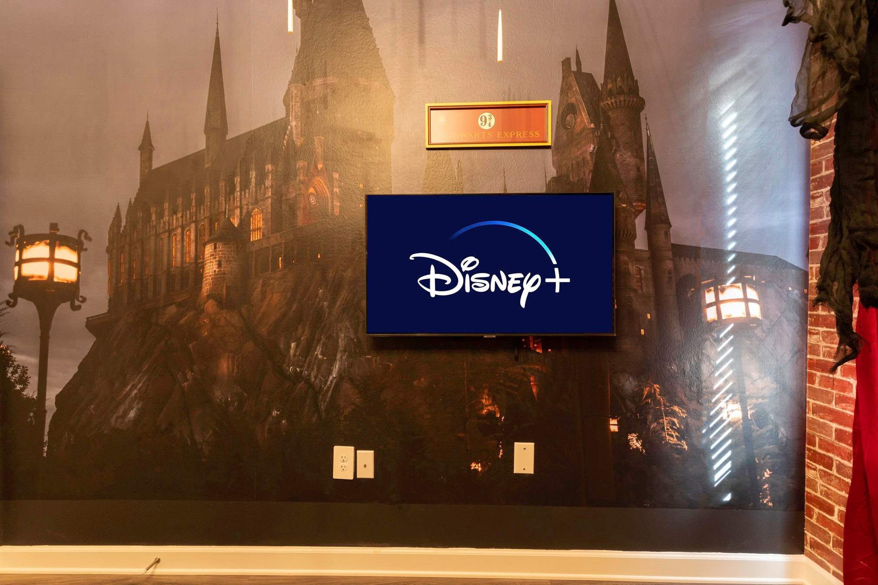 Eine Wand mit dem Disney+-Logo und einem Schild mit Aufschrift Hogwarts Express.