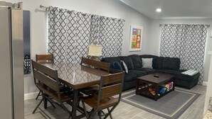 Una sala de estar moderna con una mesa de comedor, sofá y mesa de centro.