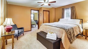 A bedroom with a bed, a chair, a table, a ceiling fan, and a window with curtains. - Grill, Dine & Relax Outside: Home in Tyrone! (Tyrone)
