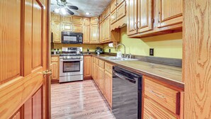 A kitchen with wooden cabinets, stainless steel appliances, and a wooden floor. - Grill, Dine & Relax Outside: Home in Tyrone! (Tyrone)