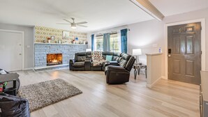 A living room with a fireplace, leather sofa, and a ceiling fan. - Pets Welcome: Quiet Silver Spring Retreat! (Silver Spring)
