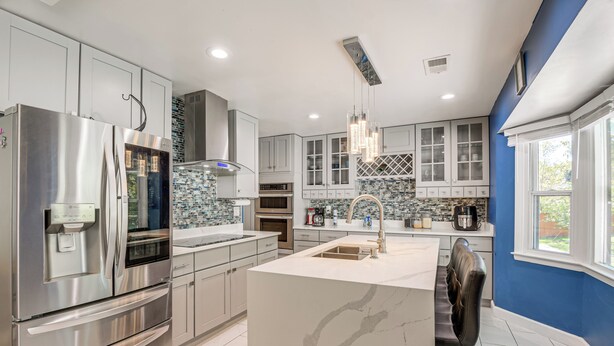 A modern kitchen with stainless steel appliances, white cabinetry, and a blue accent wall. - Pets Welcome: Quiet Silver Spring Retreat! (Silver Spring)