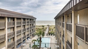 Een hotel met meerdere balkons met uitzicht op een strand en een zwembad.