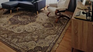 A living room with a sectional sofa, a single armchair, a wooden side table with a keyboard, and a patterned rug. - THE OLD WINE STATION APARTAMENTS in the very center of the city. (Haro)