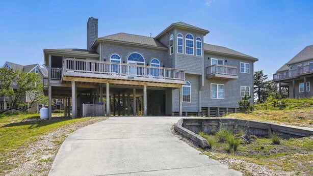 A two-story house with a covered porch and a small front yard.