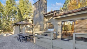 A modern house with a patio, outdoor seating, and a grill. - Hot tub, large home, family friendly, ping pong, a premier Sunriver Retreat (Sunriver)