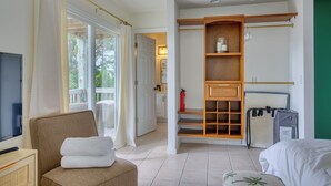 A hotel room with a television, a chair with towels, a wardrobe, and a bed. - Welcome to The Palms @ Sneads Ferry, NC! (Sneads Ferry)