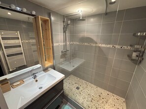 Een douche, handdoeken, zeep, toiletpapier