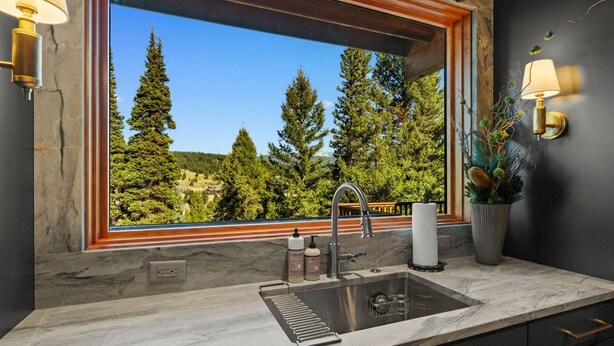 A bathroom with a large window, a sink, and a mirror. - Enchanting Home|Hot Tub|Fireplace|12m to Resort (Big Sky)