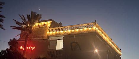 Un edificio con balcón y luces colgantes.
