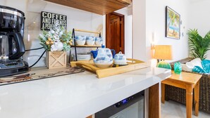 Una cocina moderna con cafetera, una bandeja de madera con tazones y un letrero que dice 'Café y Amigos'.