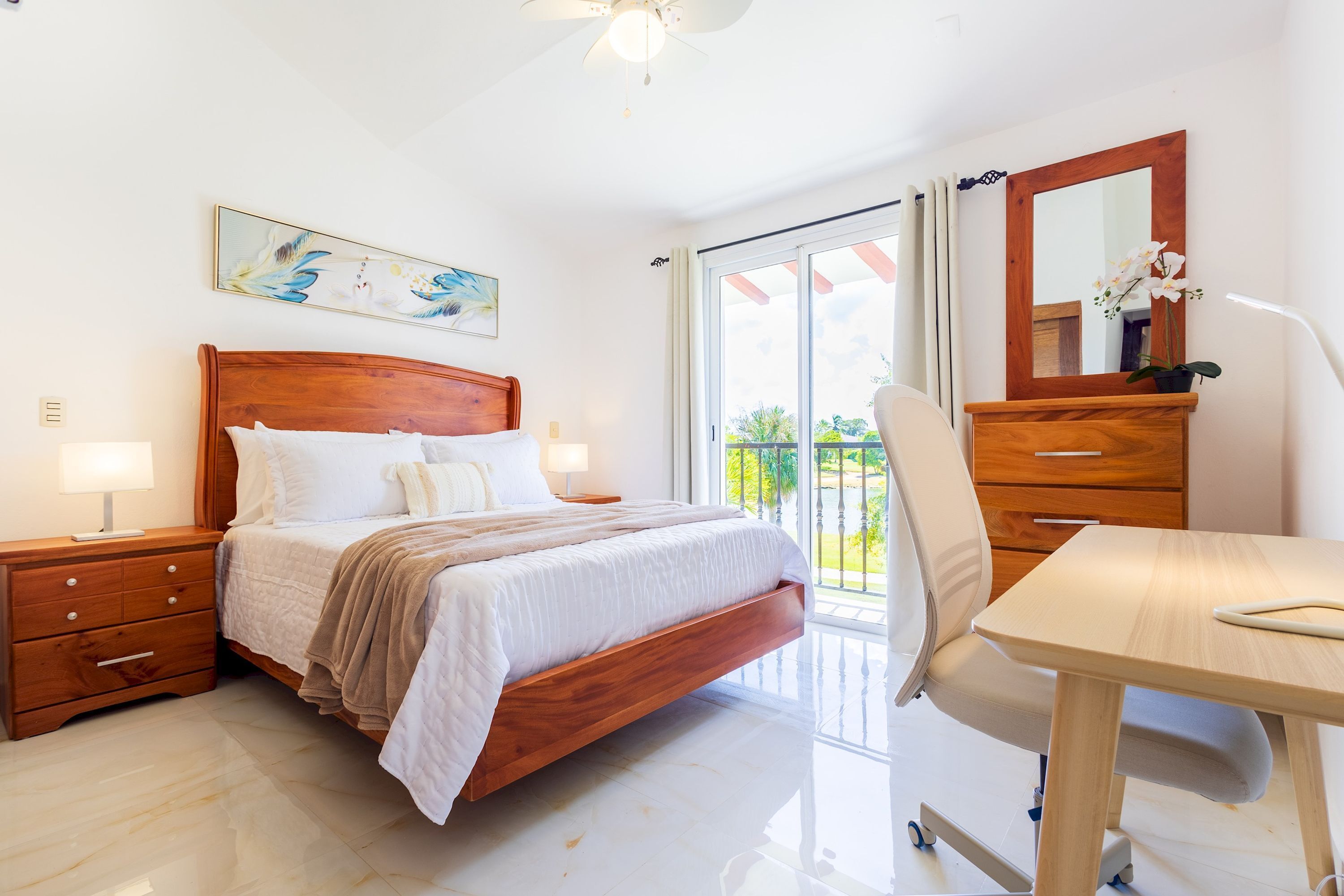 Une chambre à coucher avec un lit en bois, des tables de chevet, un bureau et une chaise.