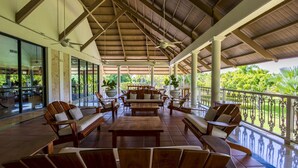 Un espacio al aire libre cubierto con mobiliario de madera y plantas en macetas.