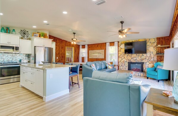 A modern kitchen with white cabinets, a central island, and a built-in oven. - Waterfront Home w/ Boat Dock & Slip in Old Town! (Old Town)