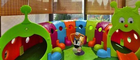 Zona de juegos con estructuras de colores y una figura de juguete.