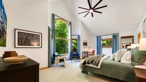Een slaapkamer met een bed, een bureau, een stoel, een raam en een plafondlamp.