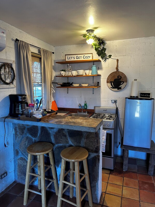 Una cocina acogedora con una isla de piedra, taburetes de madera y decoración con motivos de café.