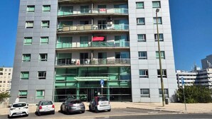 Ein mehrstöckiges Gebäude im modernen Stil, mit Balkonen und einer Glasfassade.