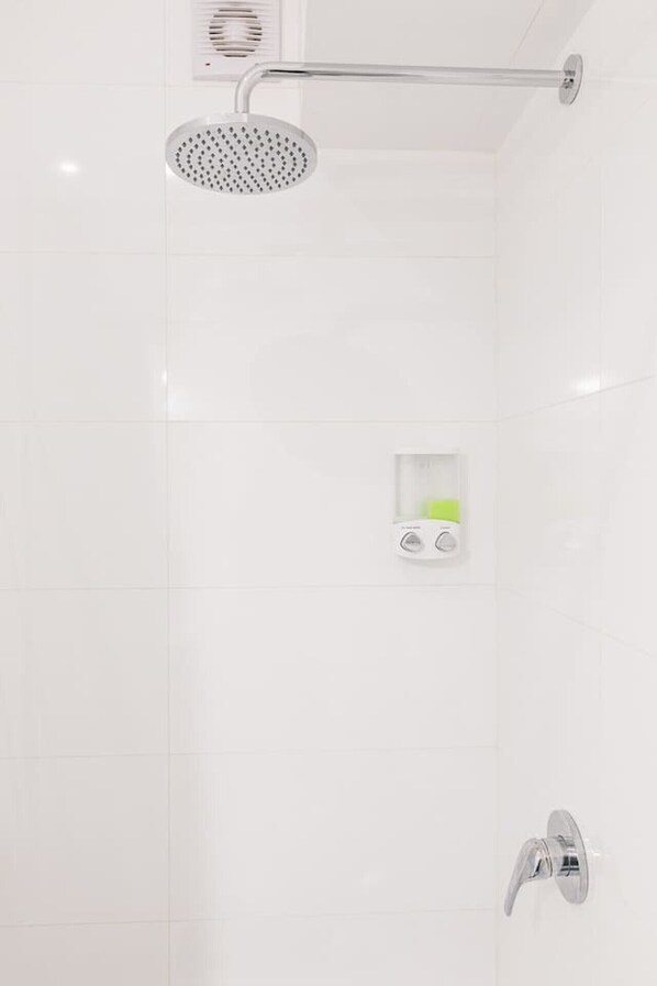 Ducha moderna con cabezal de ducha de mano, panel de control y grifo empotrado.