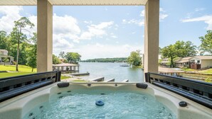 Banheira de hidromassagem com vista para um lago e casas ao redor.