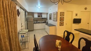 Una cocina compacta equipada con refrigerador, microondas y un comedor con mesa y sillas.