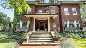 A two-story brick house with a front porch, steps, and a garden. - Historic Manor House Private Guest Suite Evanston (Evanston)
