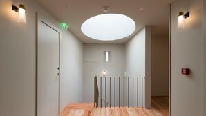 A modern hallway with a wooden floor, a glass railing, and recessed ceiling lighting. - Casa Zogbi hotel (Porto)