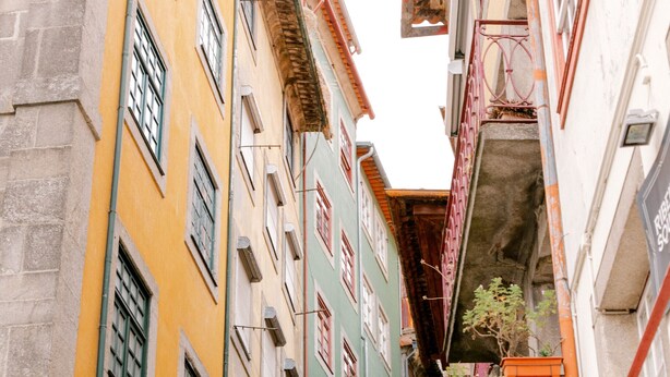 A narrow street with colorful buildings, a visible sign for 'Jinao', and a red sign hanging from a balcony. - Casa Zogbi hotel (Porto)