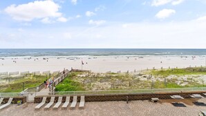 A beach with a wooden walkway leading to the shore, a flag, and a paved area with benches. - 🏝️Beachfront-Spacious Balcony-Pool-Romar Place 305🏝️ (Orange Beach)